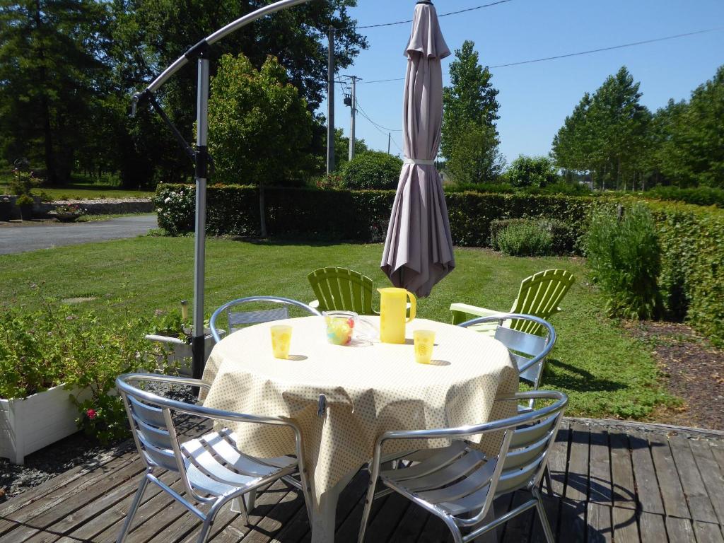 einen Tisch und Stühle mit Sonnenschirm auf einer Terrasse in der Unterkunft Gîte La Chapelle-aux-Choux, 2 pièces, 3 personnes - FR-1-410-131 in La Chapelle-aux-Choux