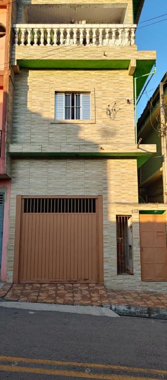 uma casa com uma porta de garagem castanha numa rua em Casa Temporada em Embu das Artes em Embu
