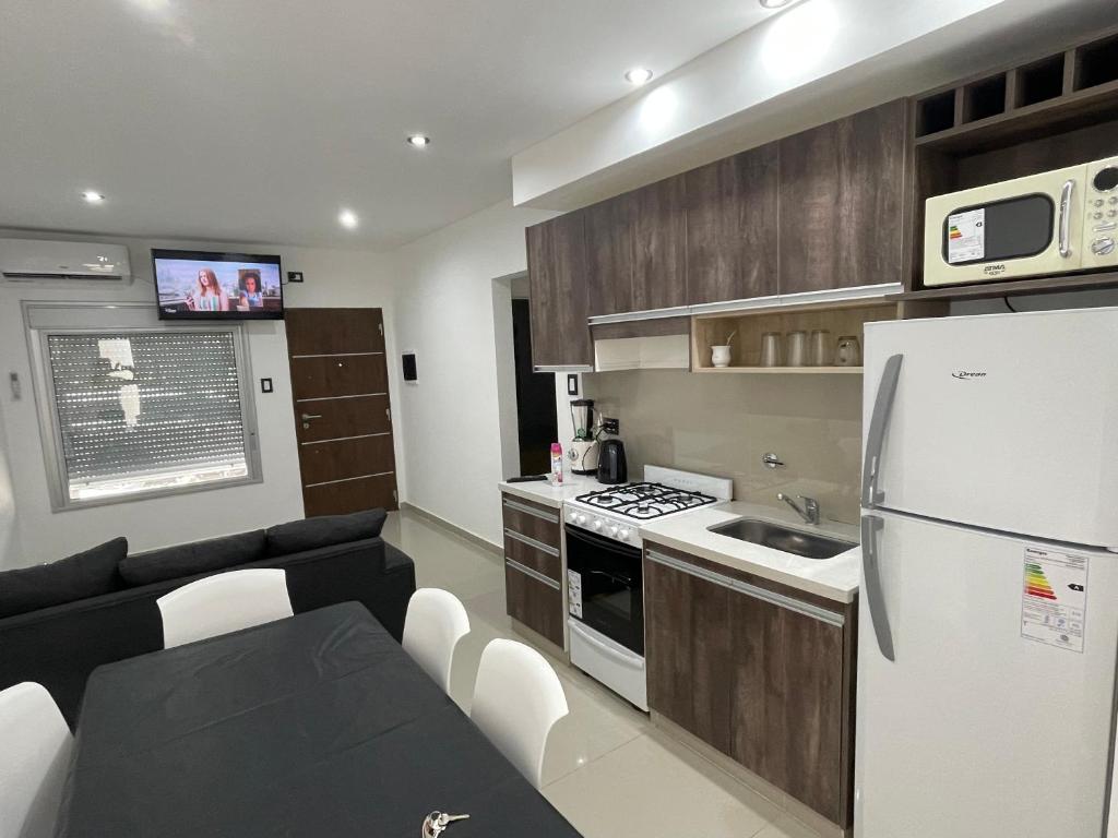 a small kitchen with a white refrigerator and a couch at Soldemonte in Monte Hermoso