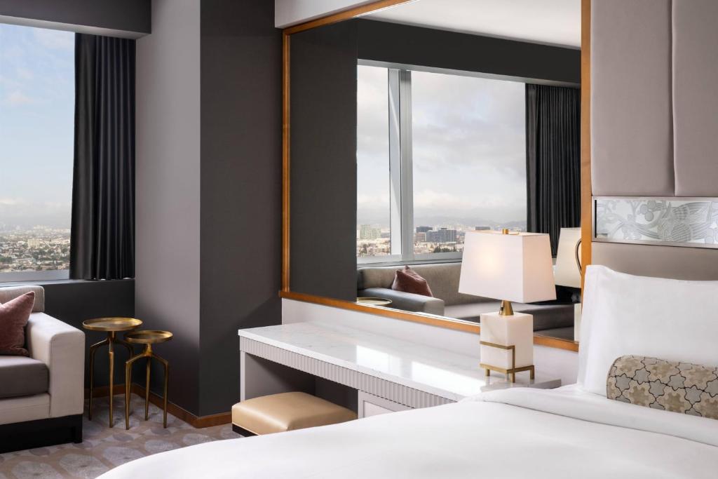 a hotel room with a bed and a mirror at The Ritz-Carlton, Los Angeles L.A. Live in Los Angeles