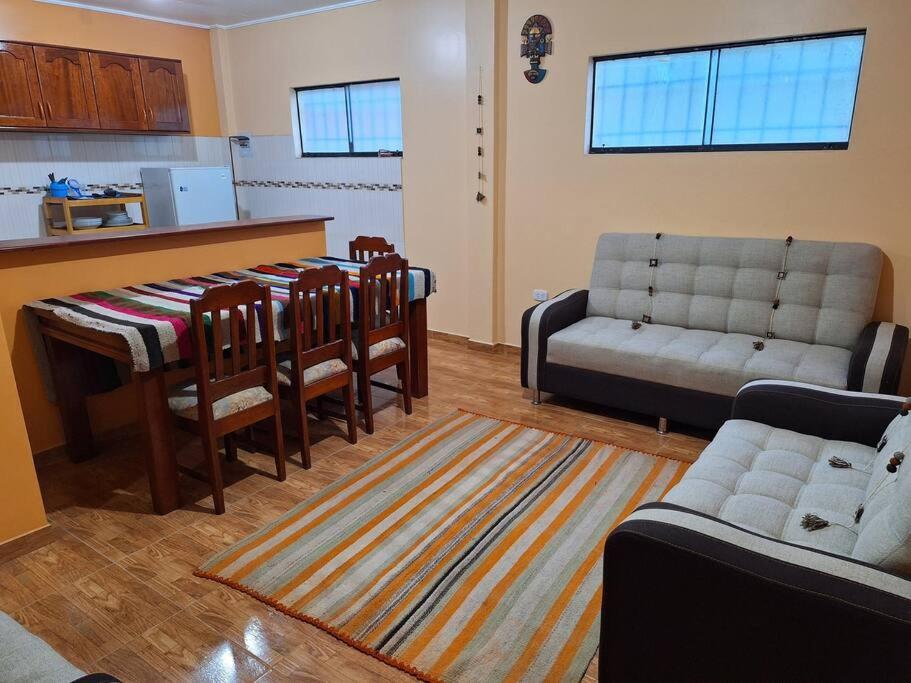 ein Wohnzimmer mit einem Sofa, einem Tisch und Stühlen in der Unterkunft Cozy home with garden overlooking the Vilcanota river in Pisac