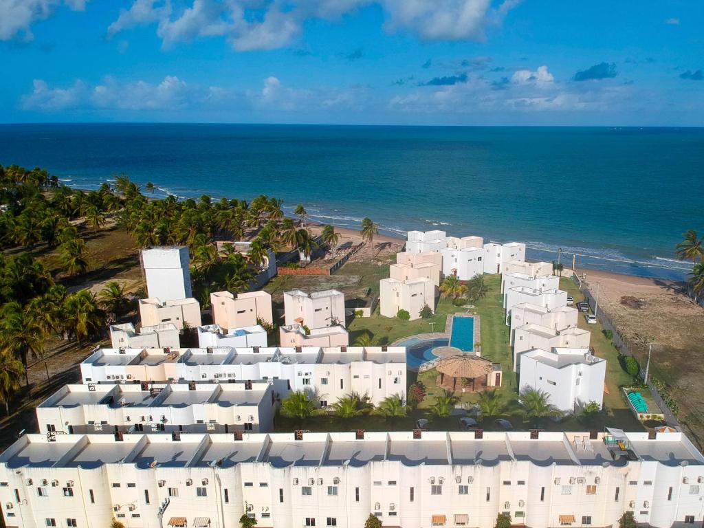 een luchtzicht op witte gebouwen op het strand bij Paraíso de Maracajaú 4 in Maxaranguape
