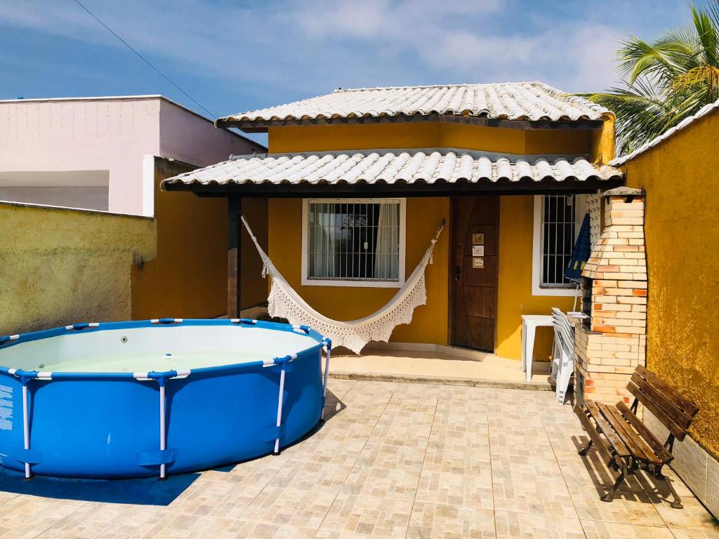 a hot tub in front of a house at Casa Amarela de Praia in Maricá