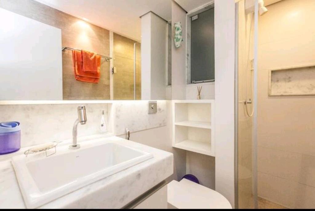 a white bathroom with a sink and a toilet at Boa Opção Asa Sul in Brasilia