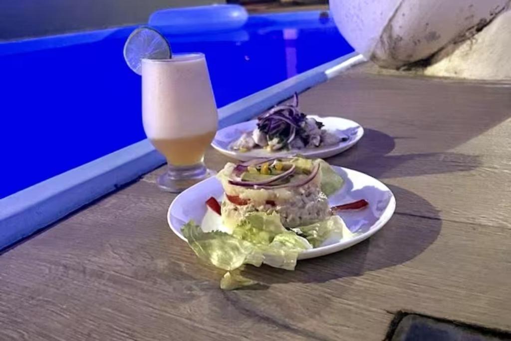 deux plaques alimentaires sur une table avec un verre de lait dans l'établissement suite arraial, à Arraial d'Ajuda