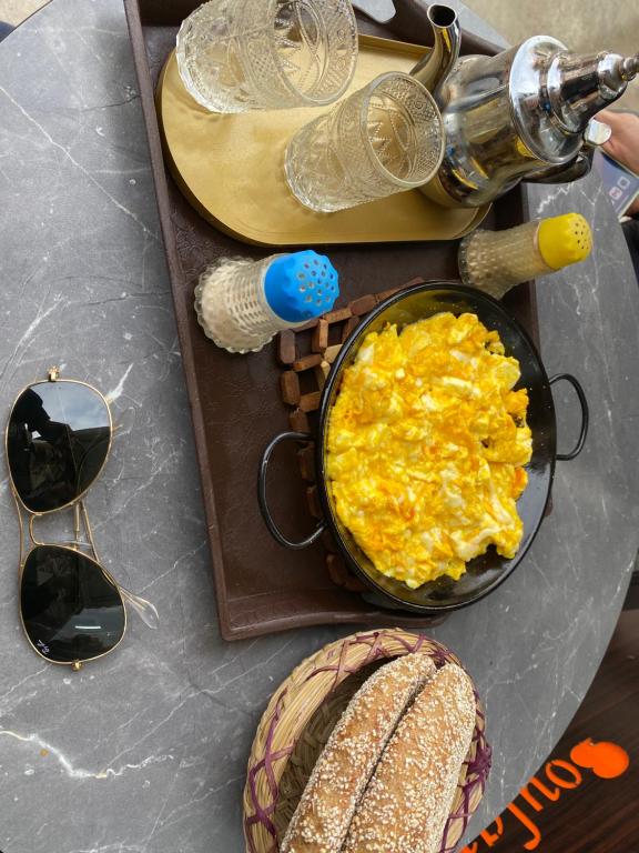 a table with a bowl of scrambled eggs and glasses at La Casa Del Colonel in Marrakesh