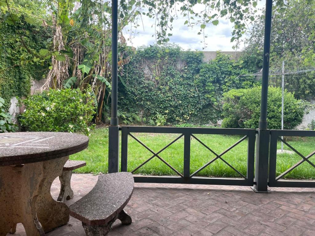 d'une terrasse avec une table et un portail donnant sur un jardin. dans l'établissement Tranquilidad en Bragado, à Bragado