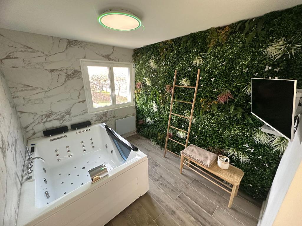 bañera en una habitación con pared verde en MarbleMood Spa en Obernai