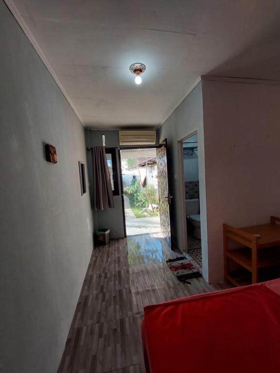 Cette chambre comprend un lit, une table et une porte. dans l'établissement Maharani Homestay, à Gorontalo
