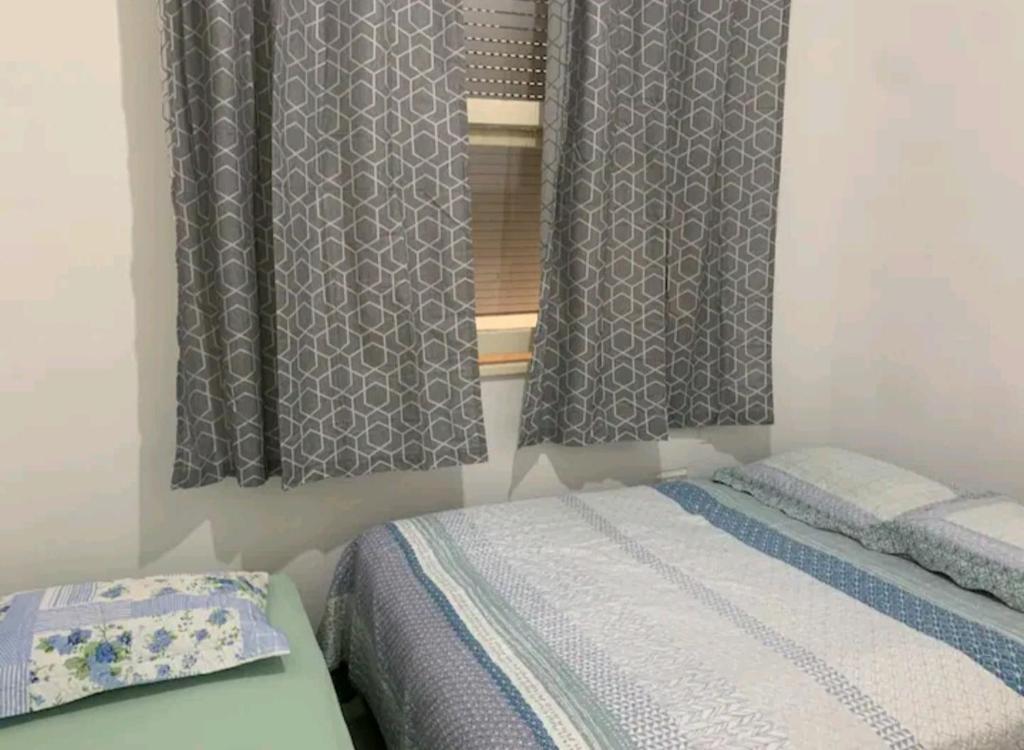 a bedroom with two beds and a window at Apto Leme RJ- Lindo 2 quartos. A uma quadra da praia. in Rio de Janeiro