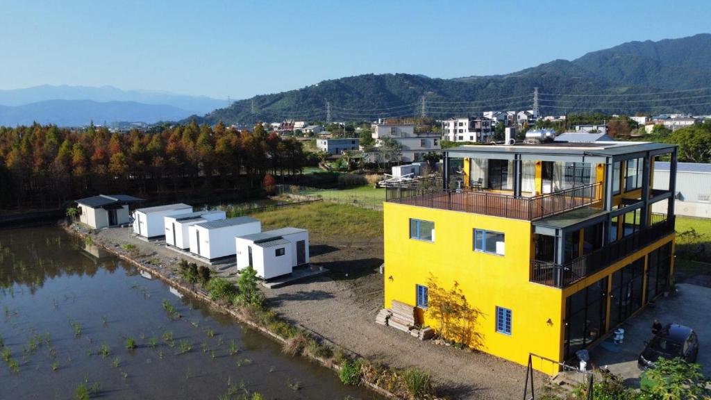 an aerial view of a yellow house on the water at 嵐羽蒔光 in Yuanshan