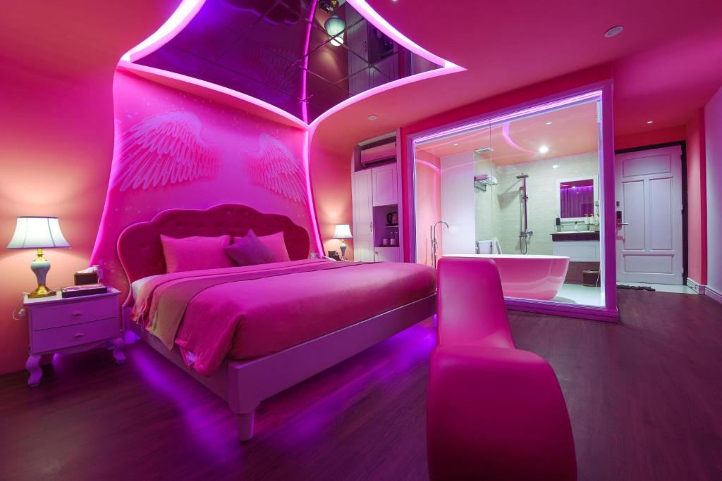 Habitación de color rosa con cama grande y bañera en Chiic House 2 - Khách sạn tình yêu en Da Nang