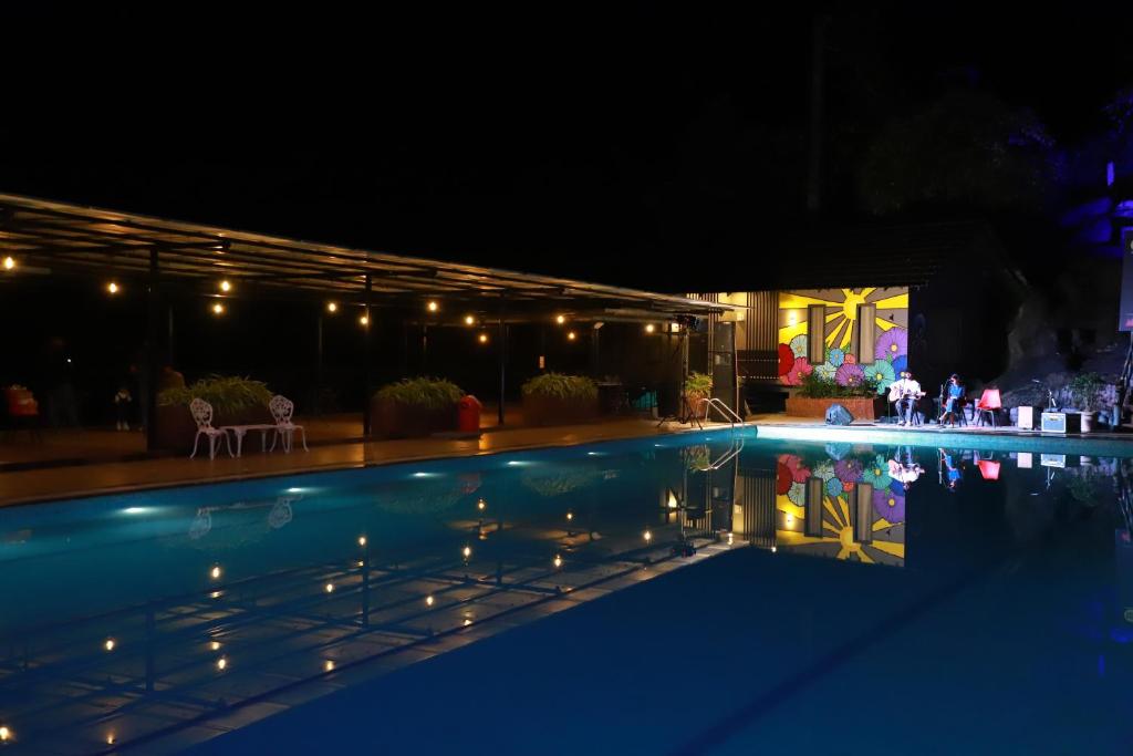 a night view of a swimming pool with lights at Konfudha Resort in Kalpetta