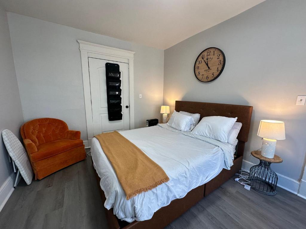 sypialnia z łóżkiem i zegarem na ścianie w obiekcie Perfect stay for couples w mieście Springfield