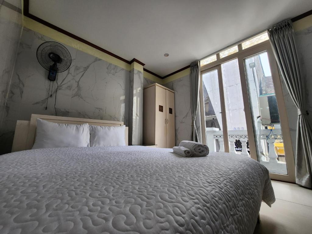 a bedroom with a large white bed with a window at TUAN Central Hotel in Hanoi