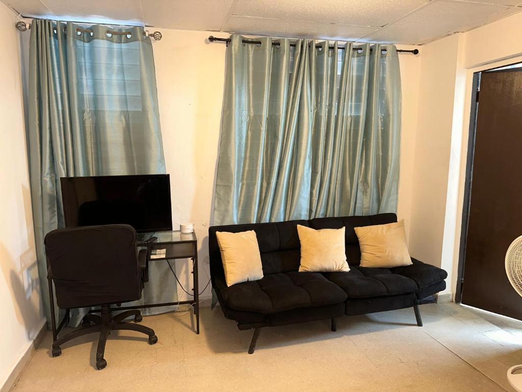 a living room with a black couch and a television at 176 Calle Perez 2A1 in San Juan