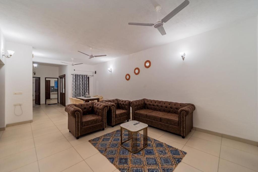 uma sala de estar com 2 sofás e uma ventoinha de tecto em FTP (French Town Palacial) em Pondicherry