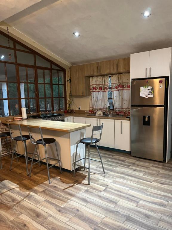 a kitchen with a table and chairs and a refrigerator at Finca Campestre Los Pinos in Arteaga