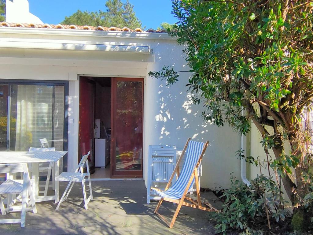 une table et des chaises devant une maison dans l'établissement Maison familiale près de la mer avec terrasse et véranda, quartier calme à Saint Jean de Monts - FR-1-323-502, à Saint-Jean-de-Monts