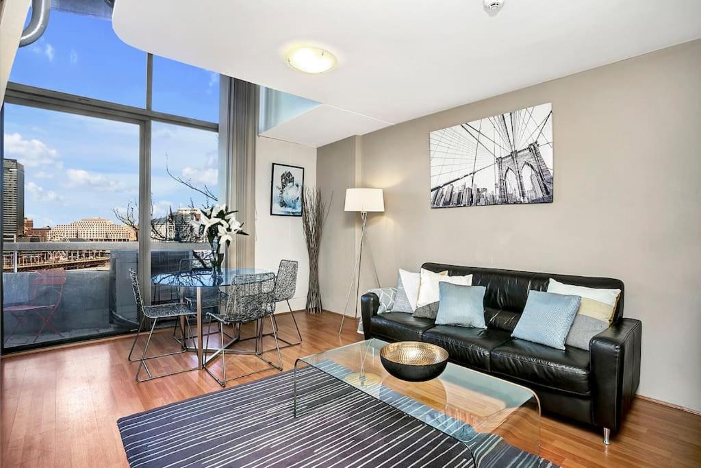 a living room with a couch and a table at Loftstyle One Bedroom in the Heart of CBD SX504 in Sydney