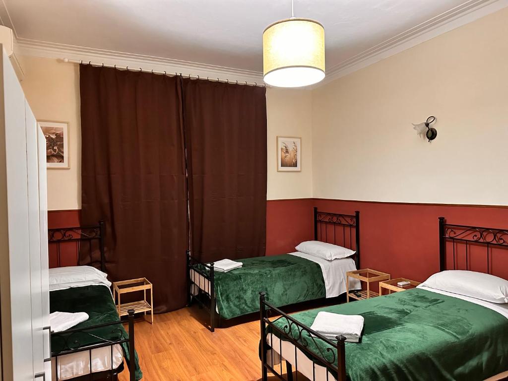 um quarto com duas camas com lençóis verdes em pardis dormitory em Roma