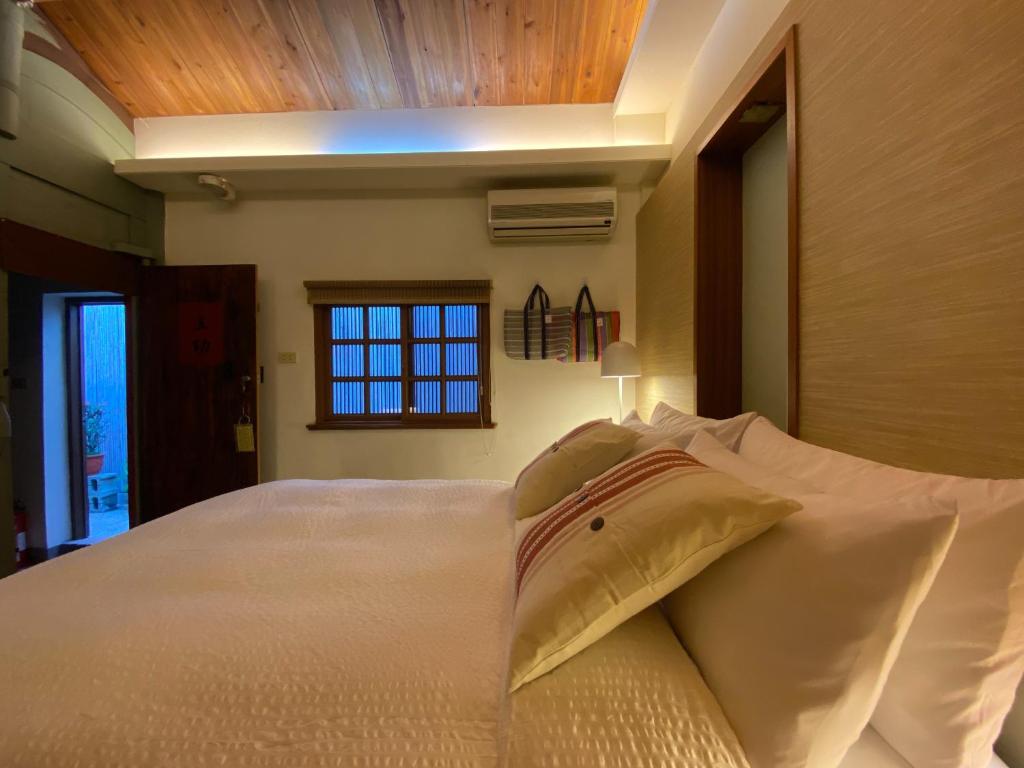 a bedroom with a large white bed with a window at 臺窩灣Tayouan Villa2024全新房間設備包棟不分租,4房6衛4床2廳1廚房,安平古堡老街走路1分鐘,花園夜市15分 in Anping