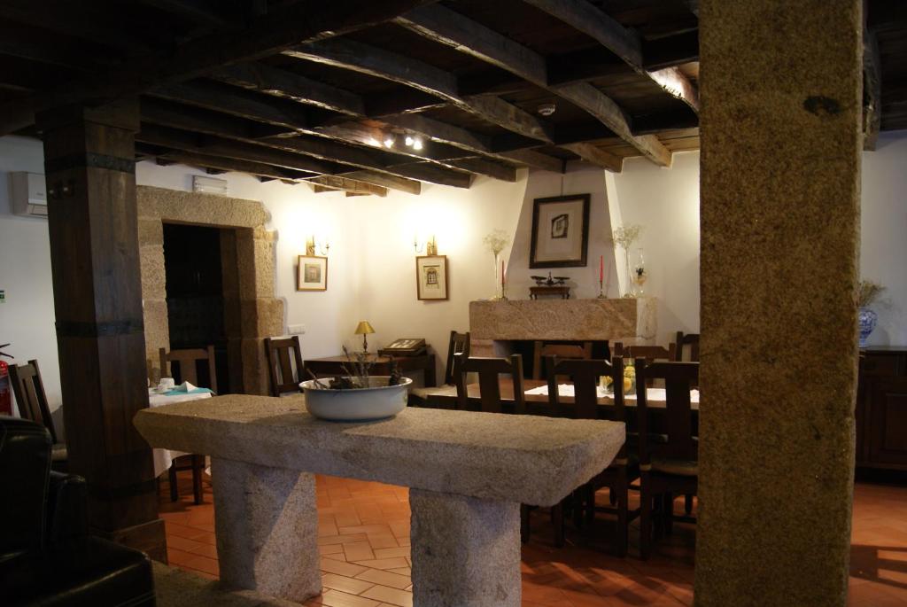 a kitchen and dining room with a large stone table at Casa d'Acha in São Miguel de Acha