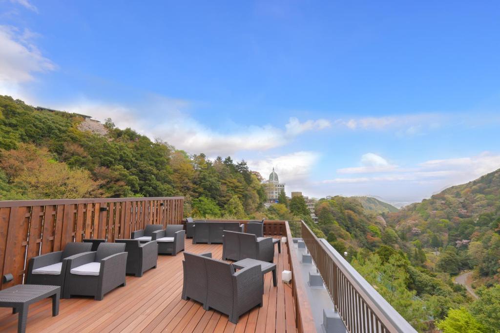 uma varanda com cadeiras e vista para as montanhas em Shikanoyu Hotel em Komono