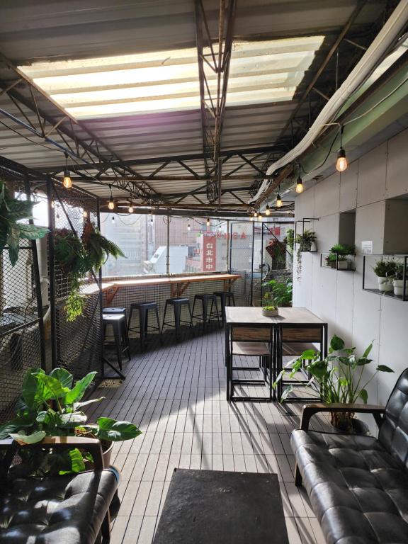 a patio with tables and chairs and plants in a building at Inn Cube - Taipei Main Station in Taipei