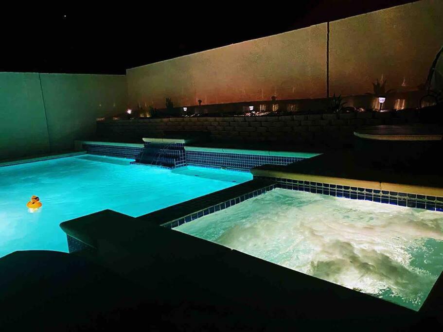 a large pool of water at night with at J’s amazing pool and hot Jaccuzi sweet house in Las Vegas