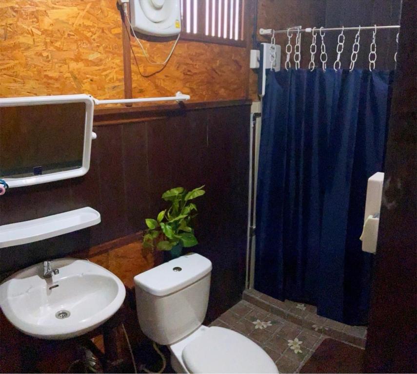 a bathroom with a toilet and a sink at Adinda house อดินดาเฮาส์ in Chiang Dao