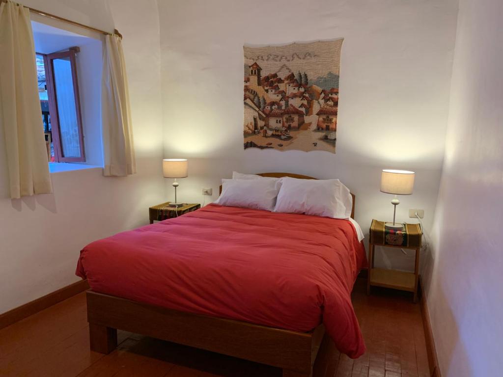 1 dormitorio con 1 cama grande de color rojo y 2 lámparas en Hospedaje Killipata, en Cusco