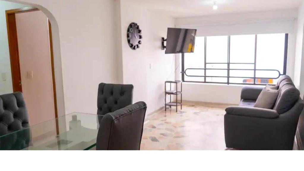 ein Wohnzimmer mit 2 Stühlen und einem Glastisch in der Unterkunft 3 Bedroom, 2 bathroom Located Cabecera del LLano. in Bucaramanga