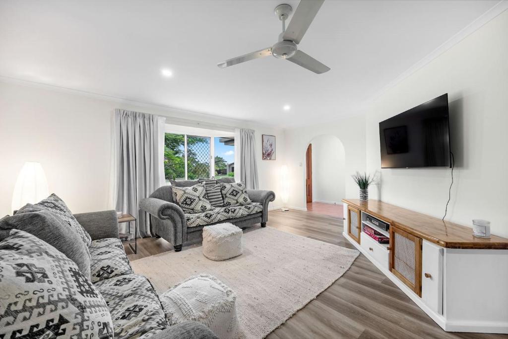 a living room with a couch and a tv at 'Hygge' Family-Friendly Comfort in Hervey Bay in Hervey Bay