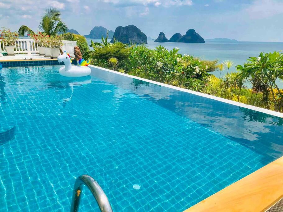 een zwembad met een opblaasbare eenhoorn in een resort bij The Sunny Hill Pool Villa 180° Panoramic Sea View 