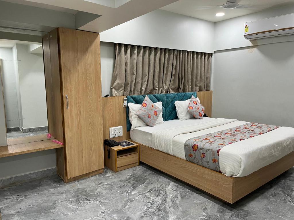 a bedroom with a large bed and a mirror at Hotel Savariya Palace in Ahmedabad