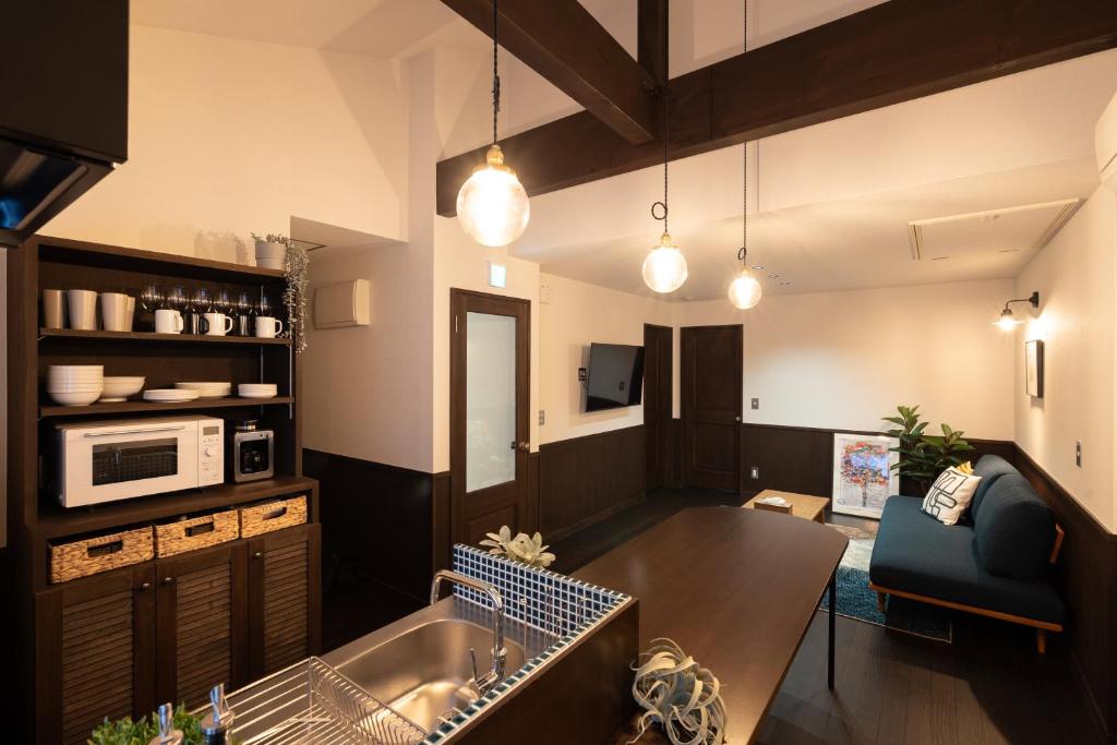 eine Küche und ein Wohnzimmer mit einem Tisch und einem Sofa in der Unterkunft 城崎温泉一棟貸し　旅宿YaDOKARI in Toyooka