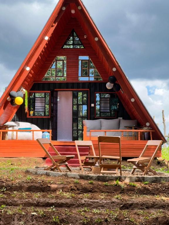 a group of chairs and a house with a roof at Aquawood Cabins in Kianyaga