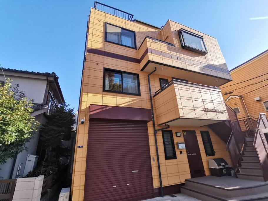 a large house with a garage in front of it at Oasis Aoto in Tokyo