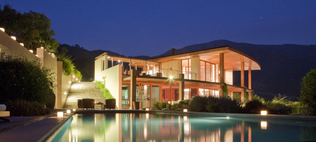 a house with a swimming pool at night at Clos Apalta Residence Relais & Chateaux in Santa Cruz