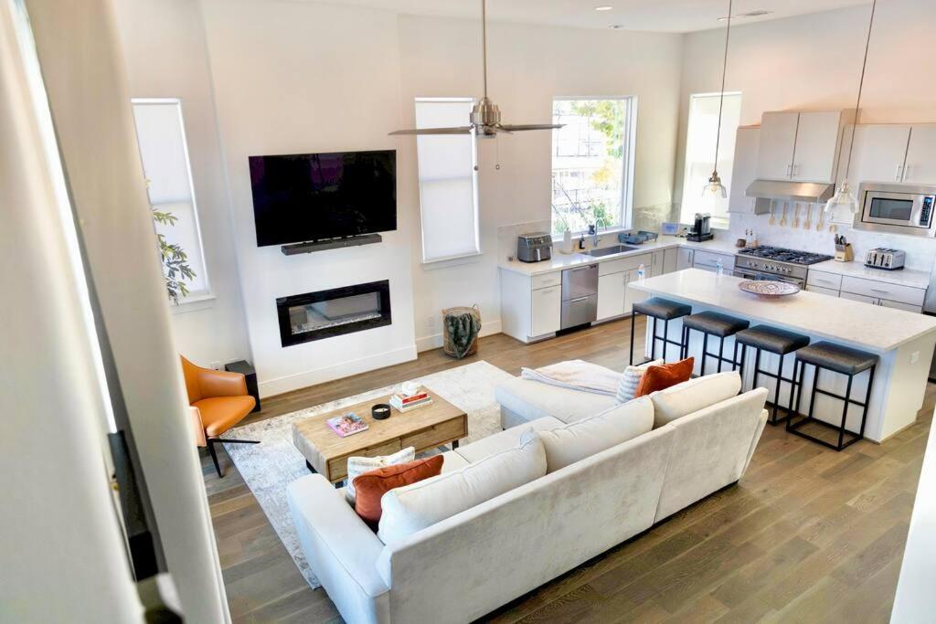 a living room with a white couch and a kitchen at Comfortable Modern Home in Downtown Houston - Sleeps 10 in Houston