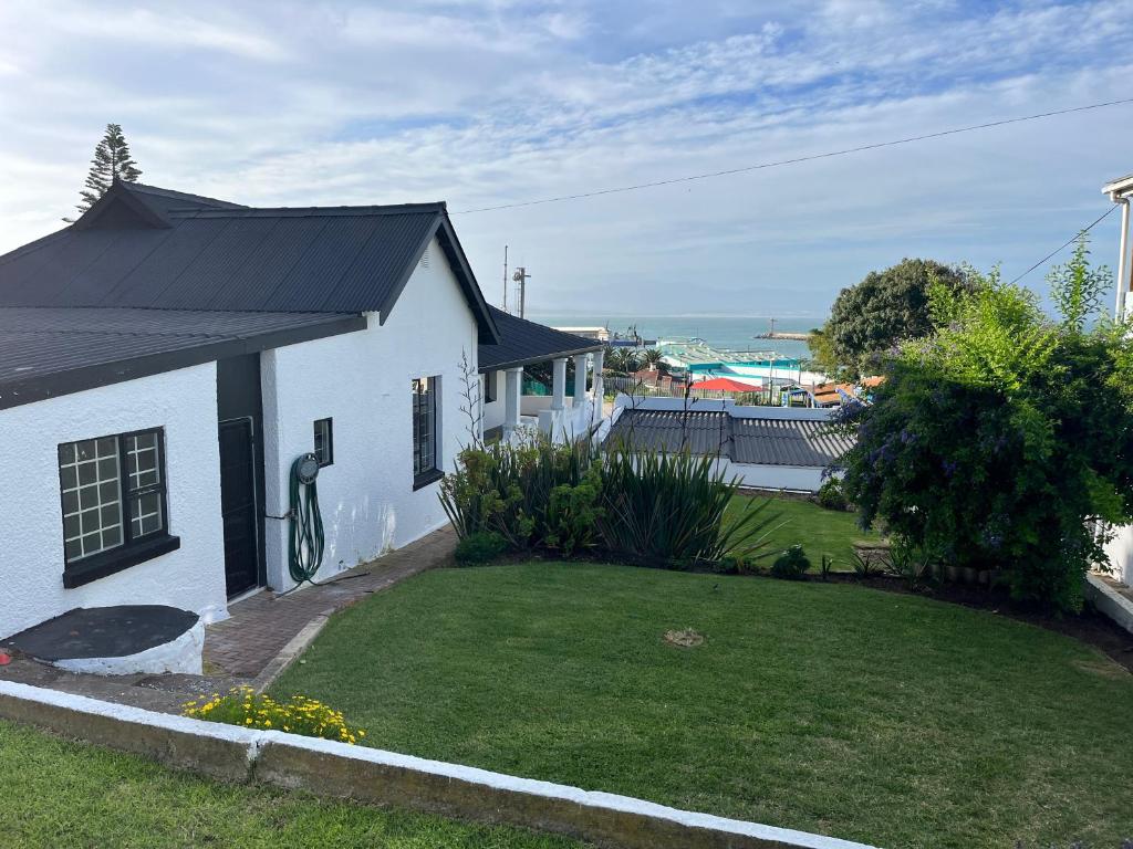a white house with a yard in front of it at Harbour View Villa. in Mossel Bay