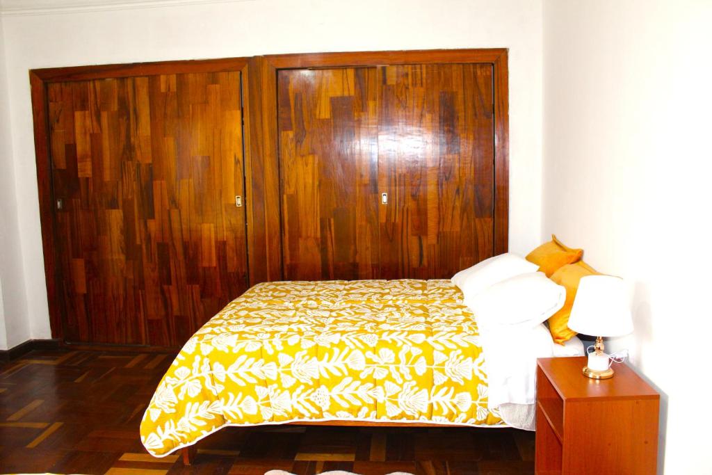 ein Schlafzimmer mit einem Bett mit einem Kopfteil aus Holz in der Unterkunft Inti Wasi II in Cusco
