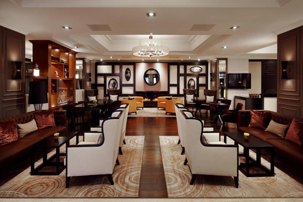 a hotel lobby with couches and tables and chairs at Hamburg Marriott Hotel in Hamburg