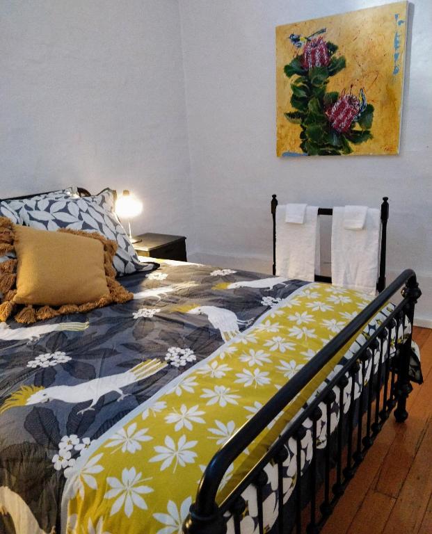 a bedroom with a bed with a yellow and white blanket at Pips on Mitchell - Beautiful Historic Apartment in Bendigo