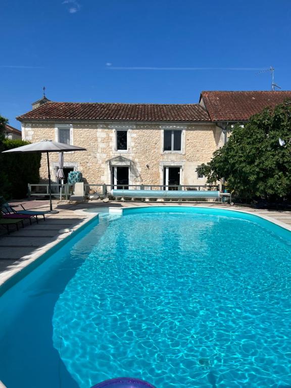 une grande piscine bleue devant une maison dans l'établissement Maison de famille avec piscine Au Coucou chanteur, à Goûts-Rossignols