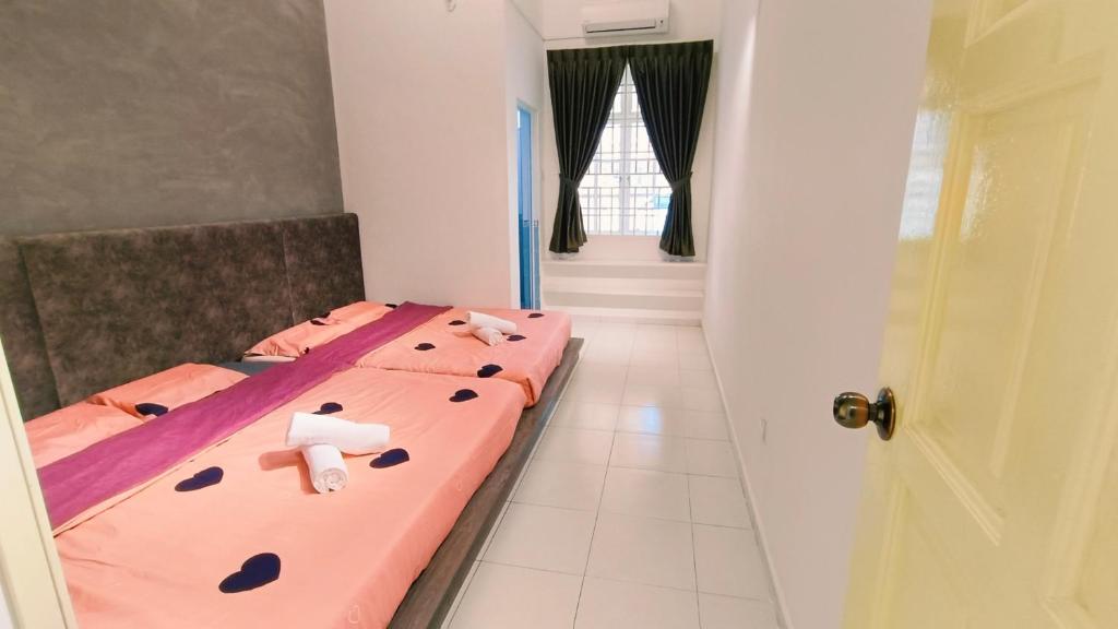 a bedroom with a pink bed and a door at 184 Kulai Homestay Tmn Gunung Pulai 3BR 9pax Shortstay in Kulai
