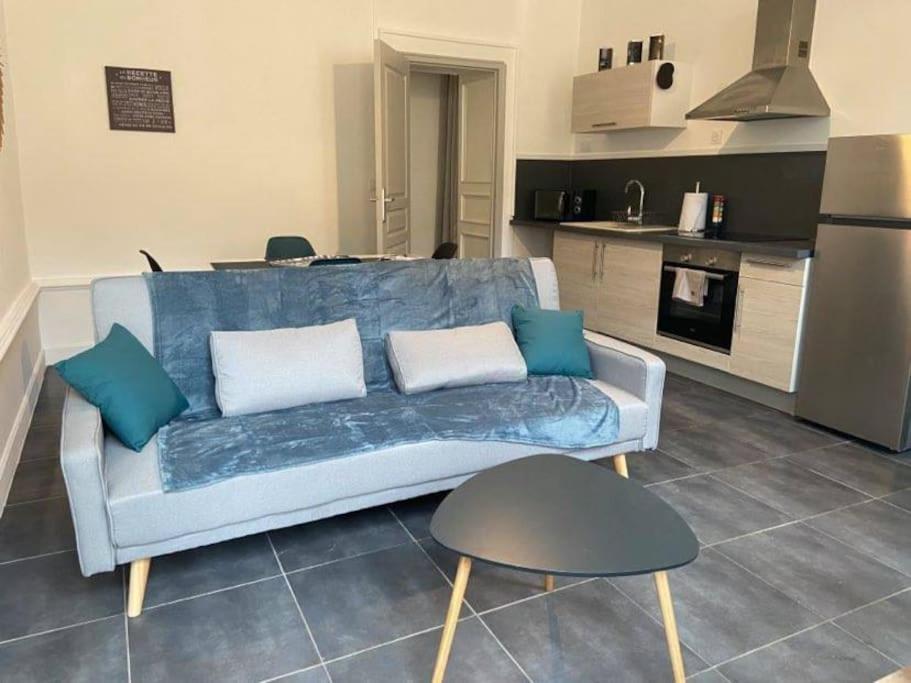 uma sala de estar com um sofá azul e uma cozinha em Le Navy Blue em Vesoul