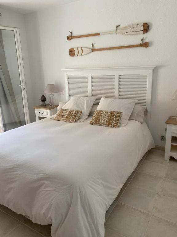 uma grande cama branca com duas almofadas em Suite dans un petit paradis em La Londe-les-Maures