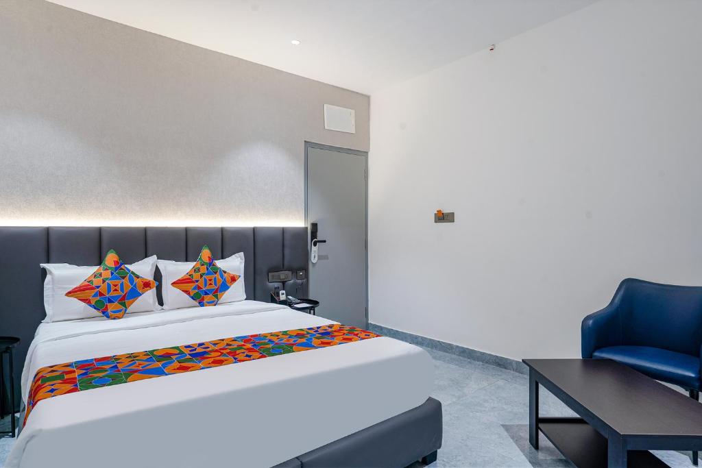 1 dormitorio con 1 cama grande y 1 silla azul en FabHotel Prime Cloud 5 Studios en Madhapur